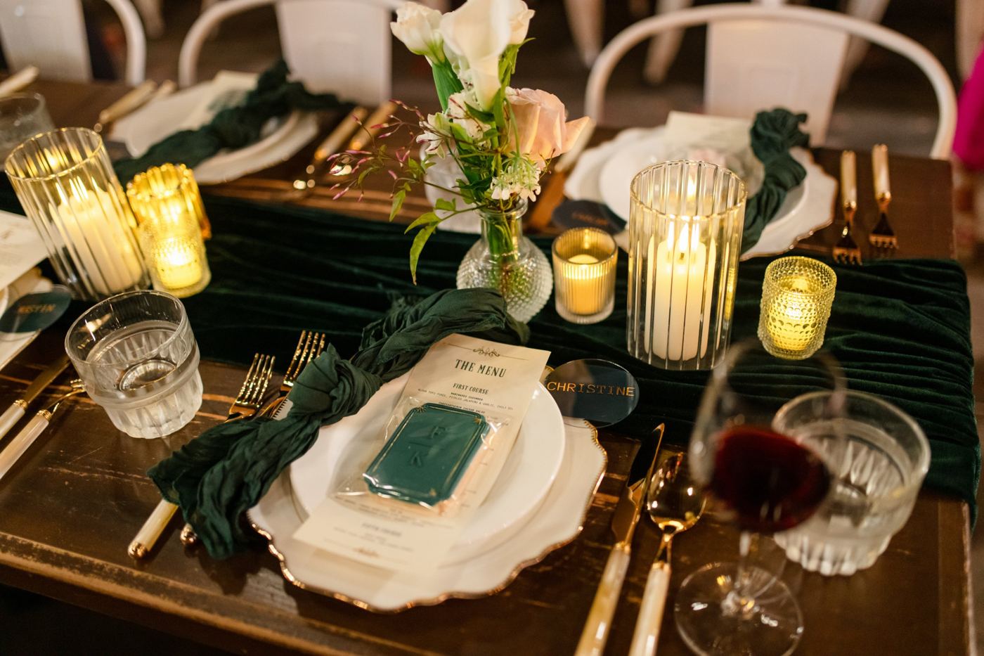 Candlelit place setting with gold-rim charger and votives
