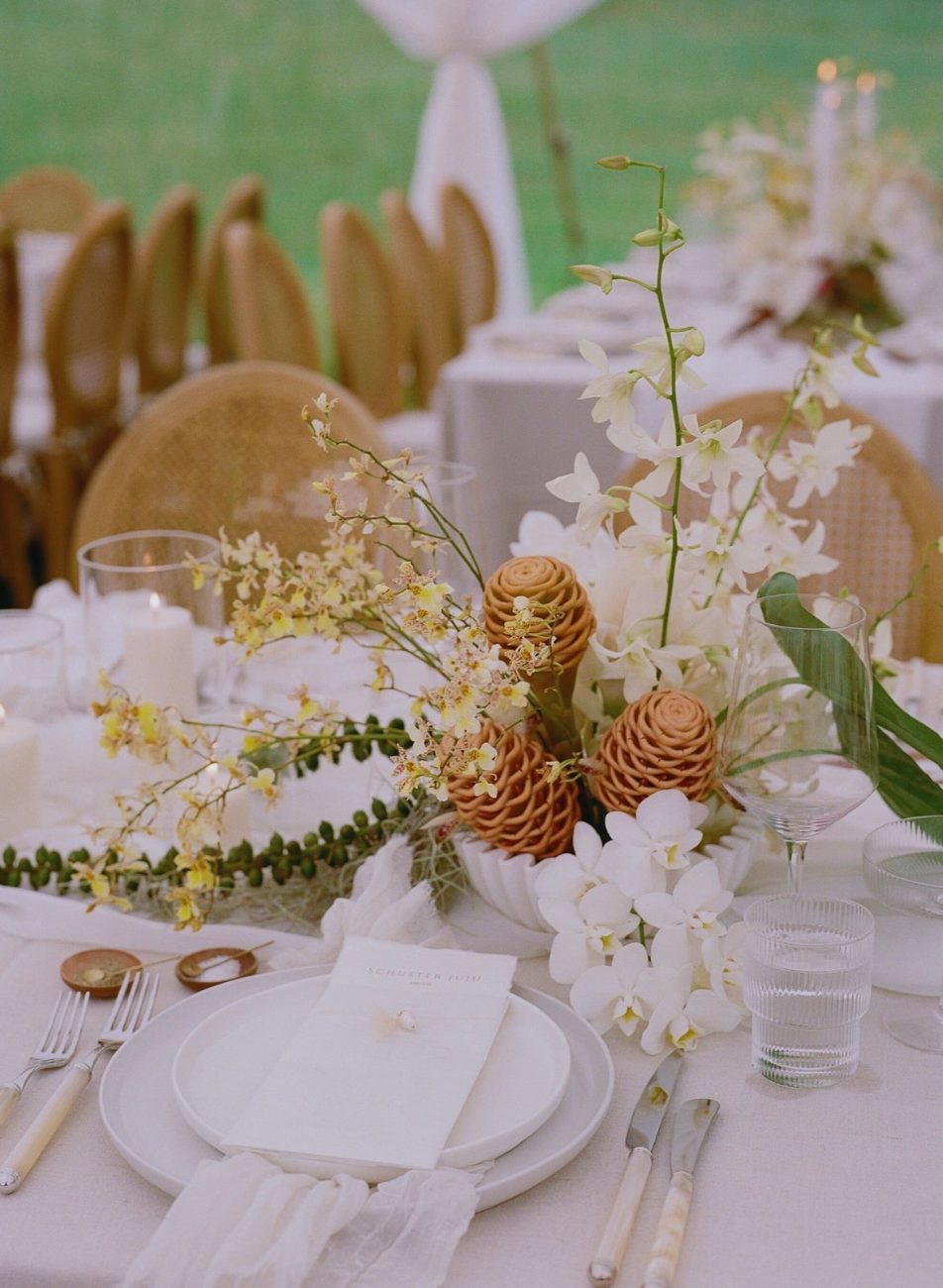 White orchid and ginger centerpiece with ivory-handled flatware and ribbed glassware